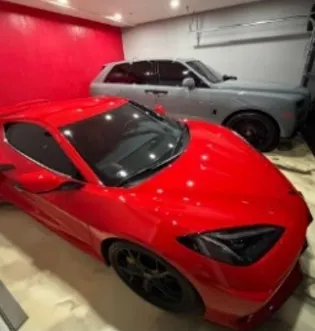 A red sports car and a gray SUV parked in a garage.