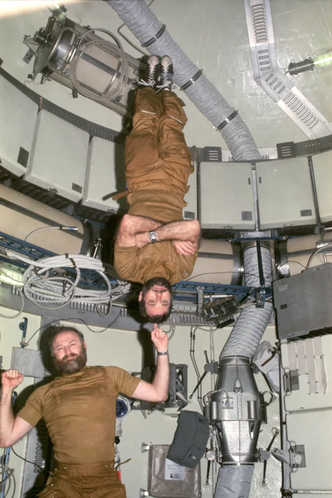 Astronauts Gerald Carr and William Pogue demonstrate weightlessness on Skylab 4.