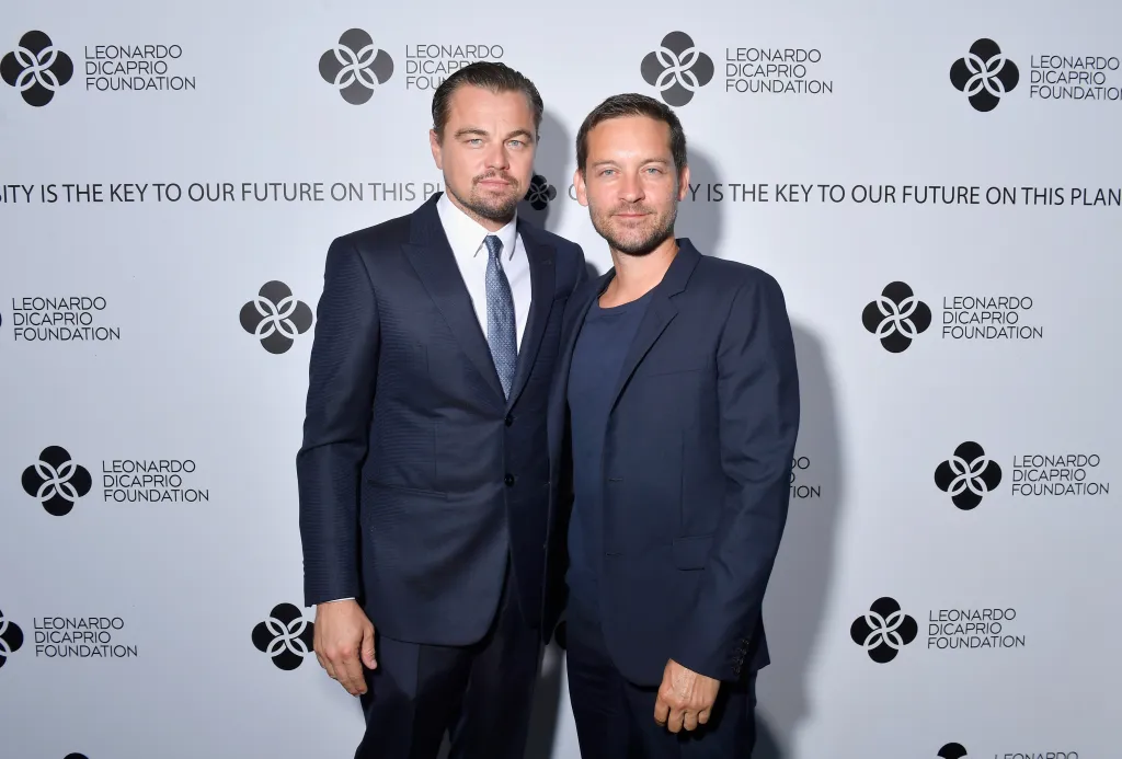 Leonardo DiCaprio and Tobey Maguire posing at the Leonardo DiCaprio Foundation gala.
