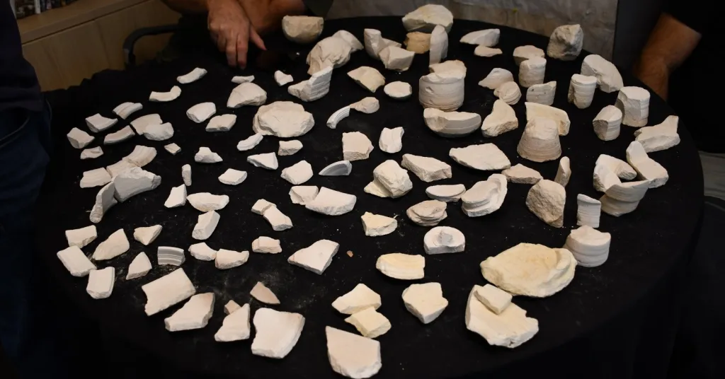 Fragments of 2,000-year-old stone vessels laid out on a black cloth.