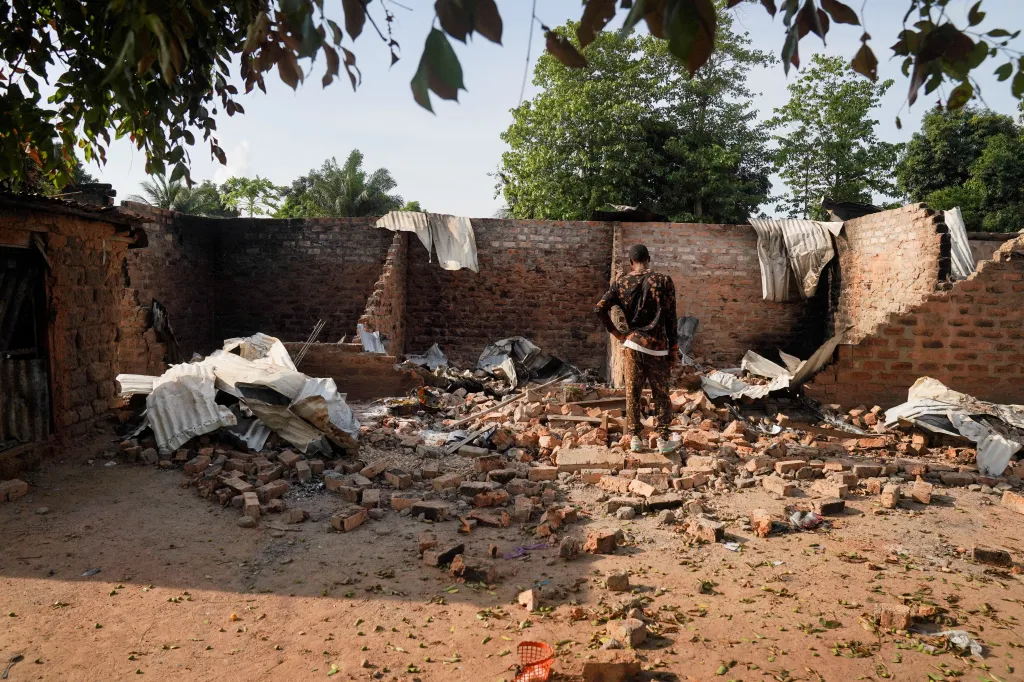 A man stands amidst the rubble of a damaged and burnt house in Yelwata, Benue State.