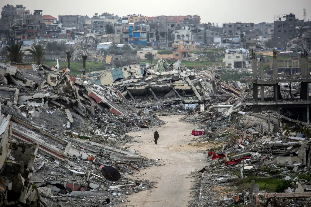 A man walks along a street through the rubble of destroyed buildings in the Zahra neighbourhood in the central Gaza Strip.