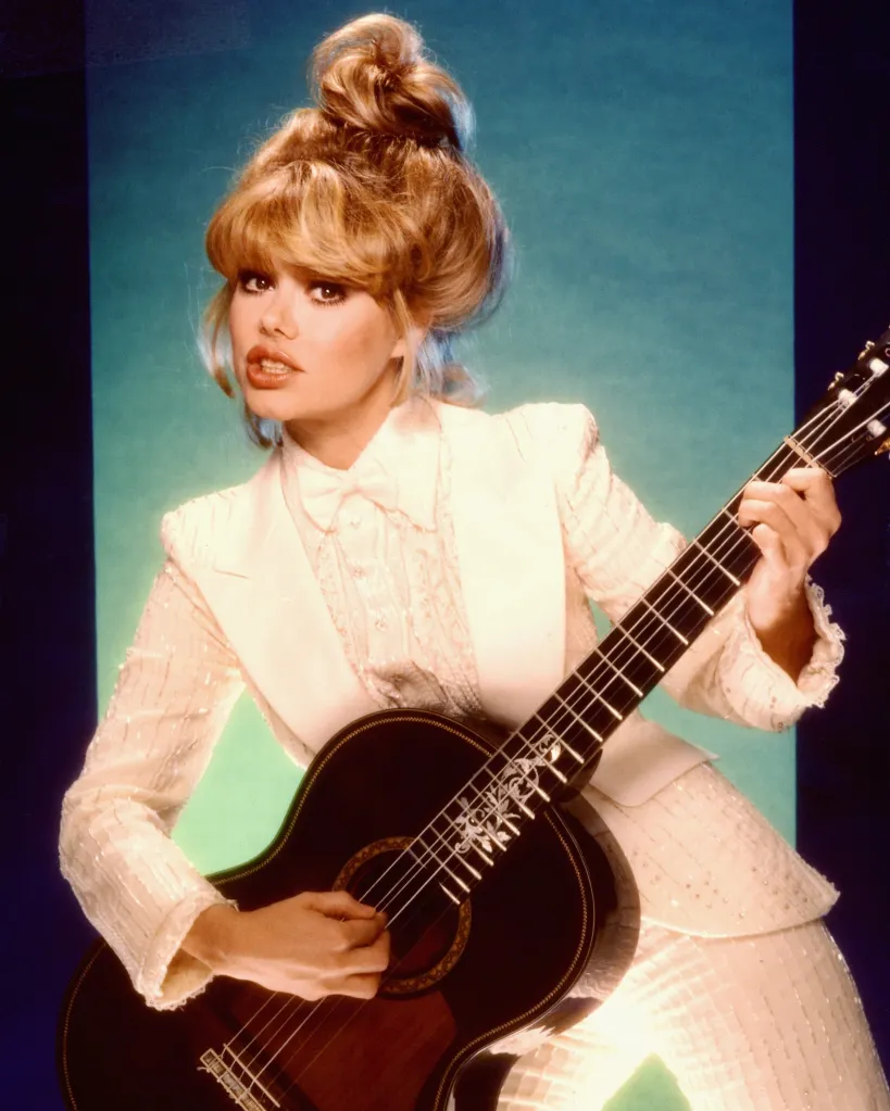 Charo, a guitarist, singer, and actress, posing for a portrait with her guitar.