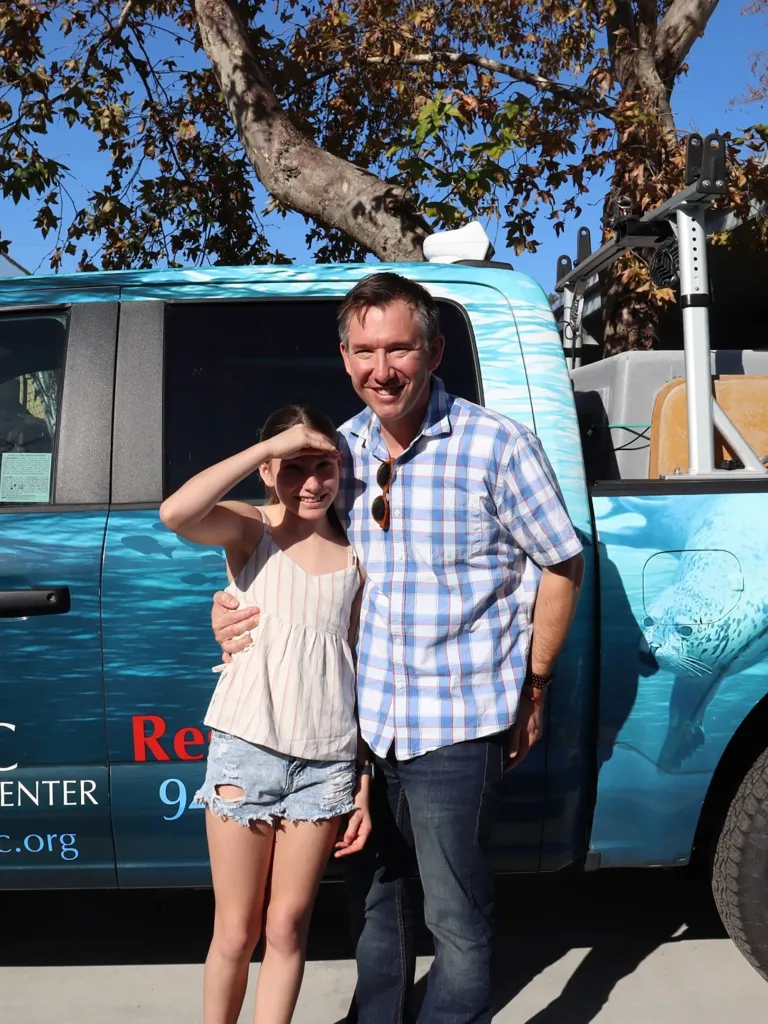 Matthew and Ellie smiling in front of a PMMC rescue truck.