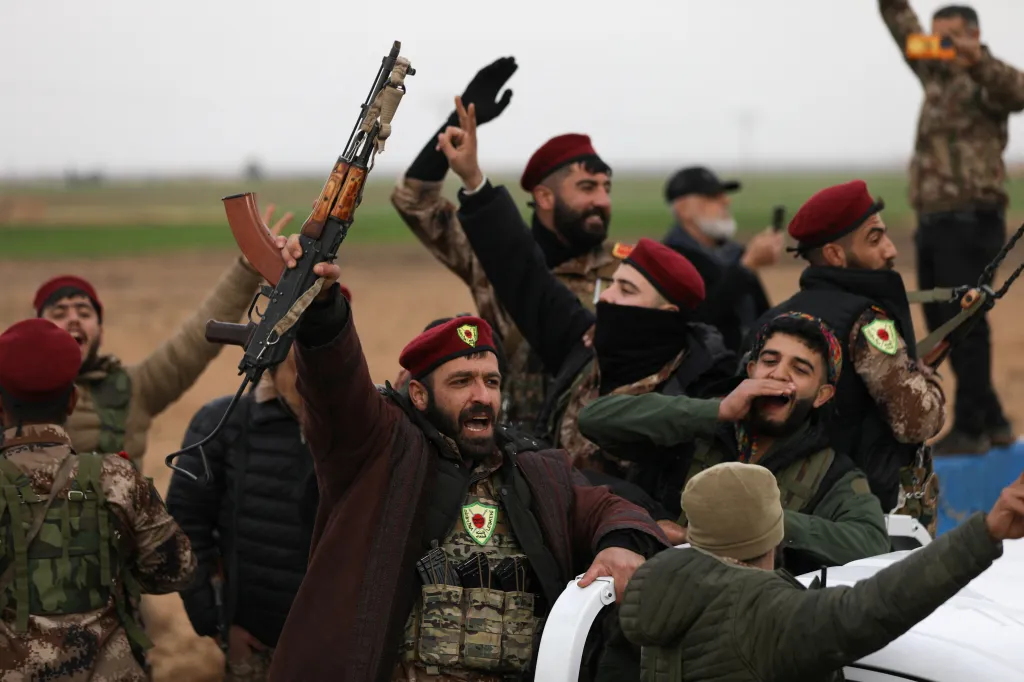 Syrian Democratic Forces members cheer after withdrawing from the front lines in Qamishli, Syria.