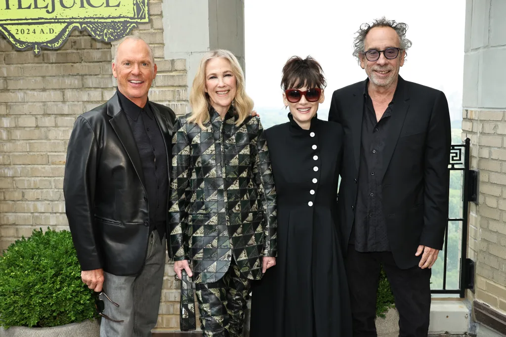 Michael Keaton, Catherine O'Hara, Winona Ryder, and Tim Burton smiling at a photo call.