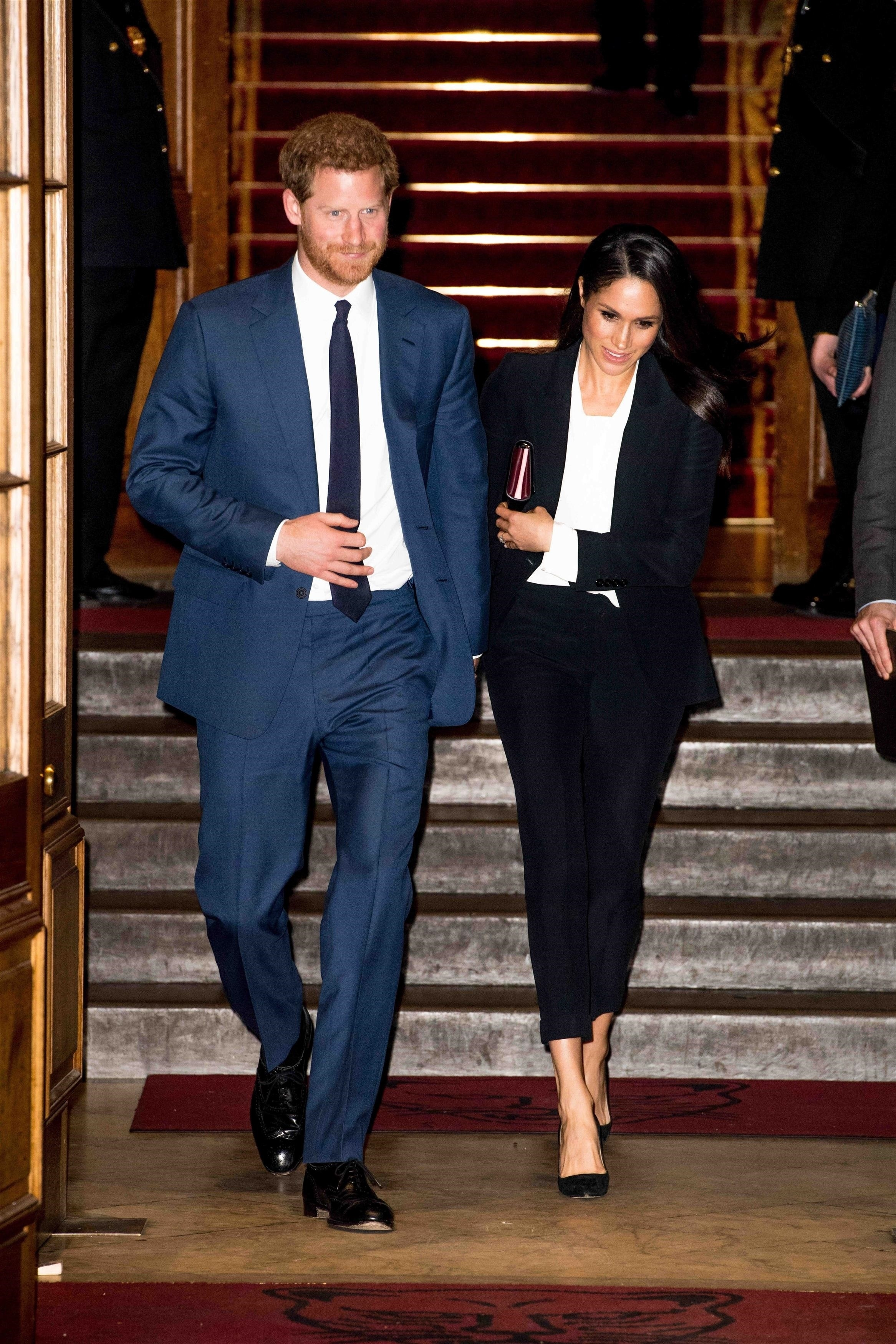 Prince Harry and Meghan Markle descending stairs.