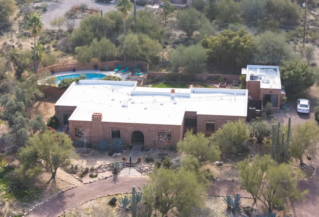 Aerial view of Nancy Guthrie's house in Tucson, Arizona, surrounded by desert vegetation, with a pool in the backyard.