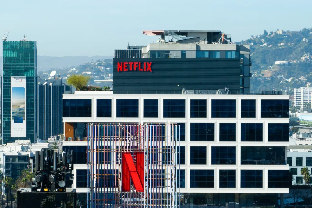A Netflix sign and the company's logo are displayed atop buildings in Los Angeles.