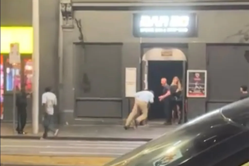 A tussle outside the venue shows one of the men being pushed to the ground by security.