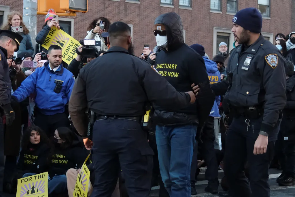 New York Police Department officers detaining a demonstrator during a protest organized by Columbia University students and professors against U.S. President Donald J. Trump's immigration policies.