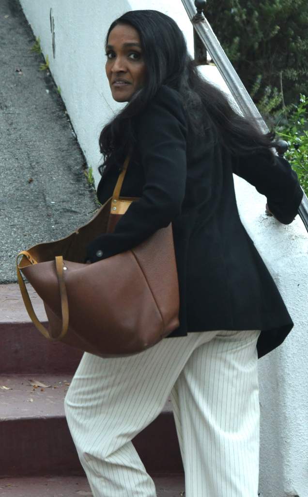 Nithya Raman, candidate for Mayor of Los Angeles, walking up steps while looking over her shoulder.
