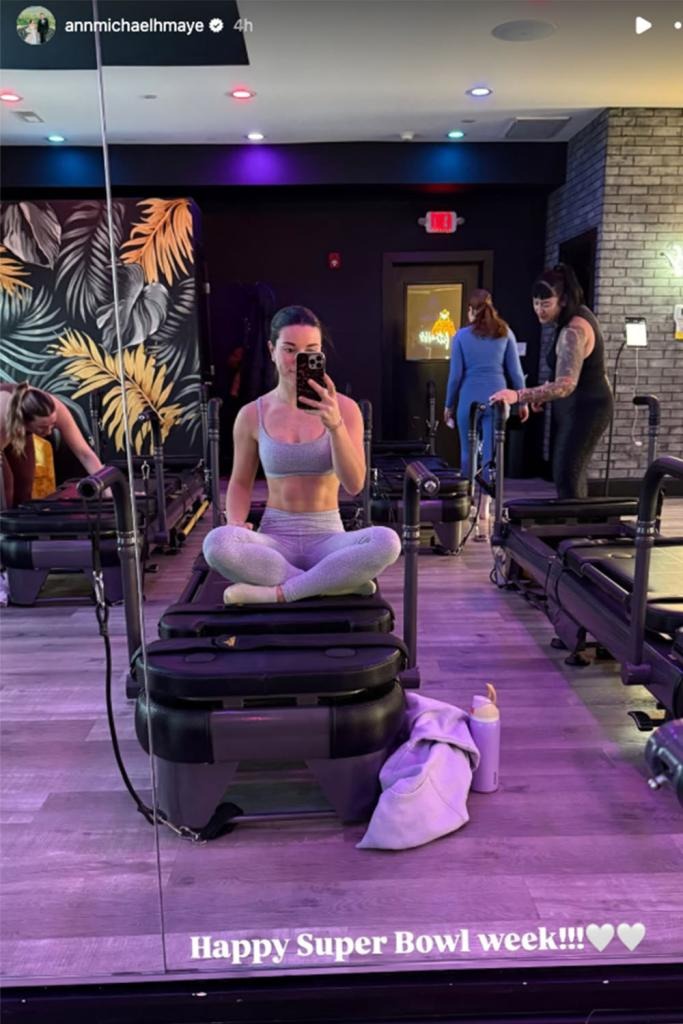 Ann Michael Maye posing for a selfie in a gym while sitting on a workout machine.