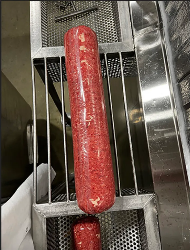 Two rolls of Fire River Farms ground beef, which was recalled for E. coli O145 contamination, on a metal rack.