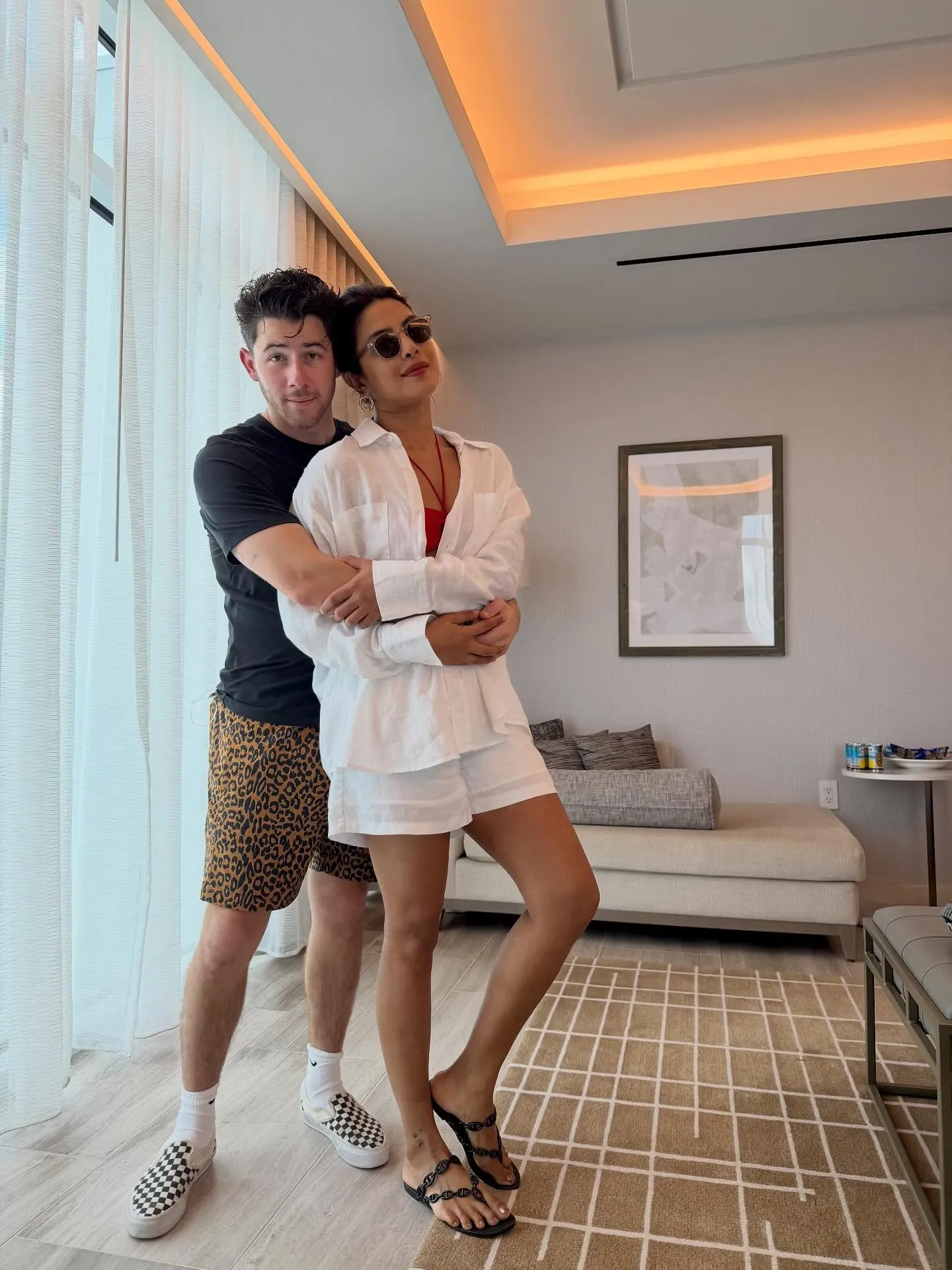 Priyanka Chopra and Nick Jonas pose together in a room.