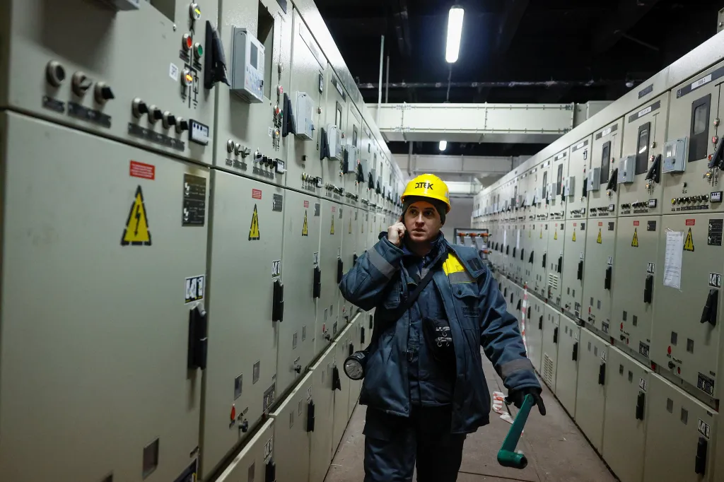 Oleksandr Zinchenko, an energy company employee, speaks on his phone while checking a power substation in Kyiv.