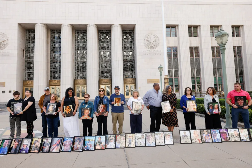 People hold a vigil outside a courthouse, displaying photos of children they lost to social media-related harms.