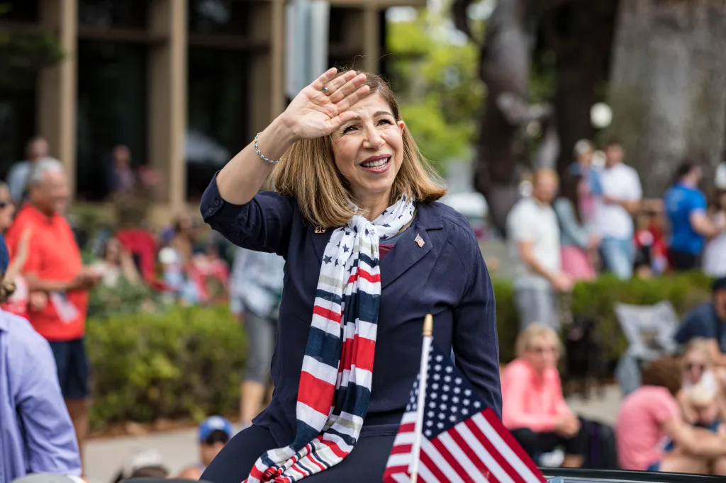 San Diego District Attorney Summer Stephan waves to a crowd during the Coronado Fourth of July Parade.