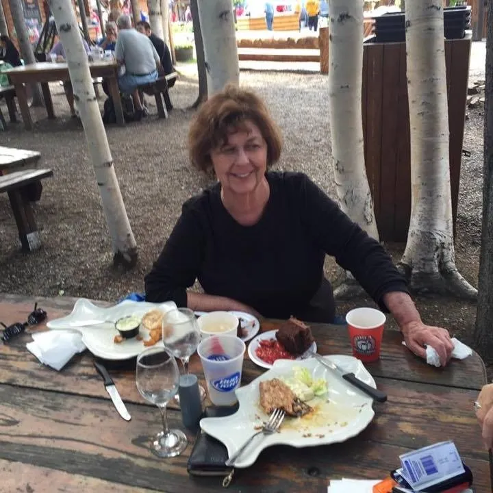 Nancy Guthrie smiling at an outdoor table with food.