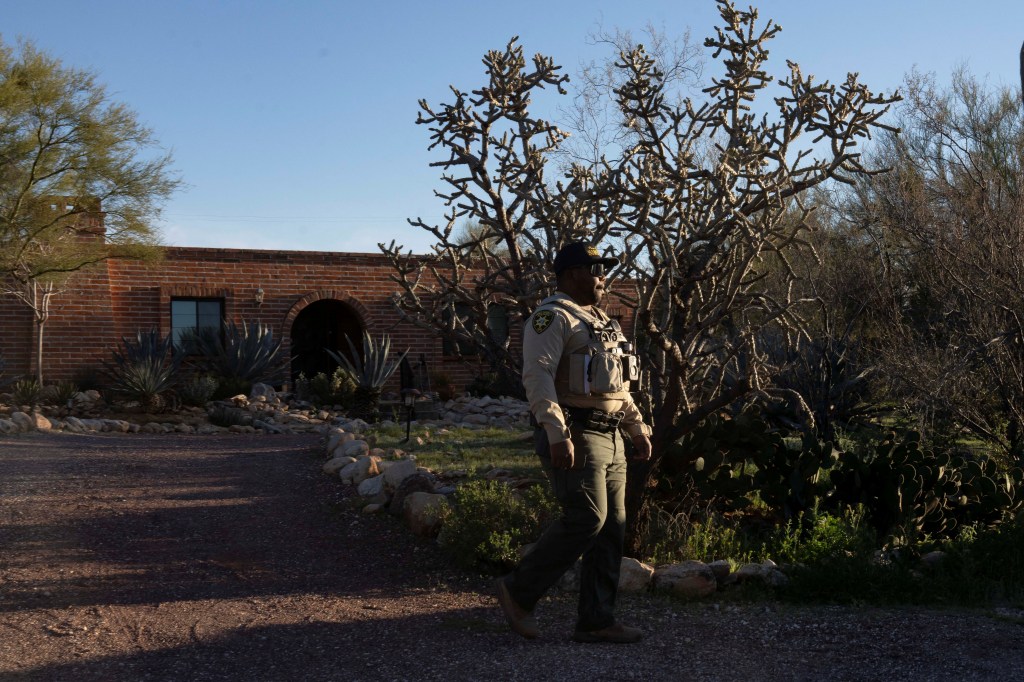 A Pima County Sheriff’s Department deputy patrols outside the home of Nancy Guthrie.