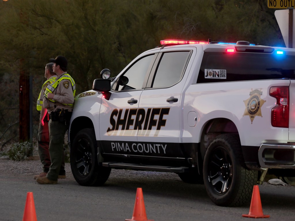 Pima County Sheriff's officers and patrol vehicle blocking off a road with traffic cones in Tucson, Arizona.