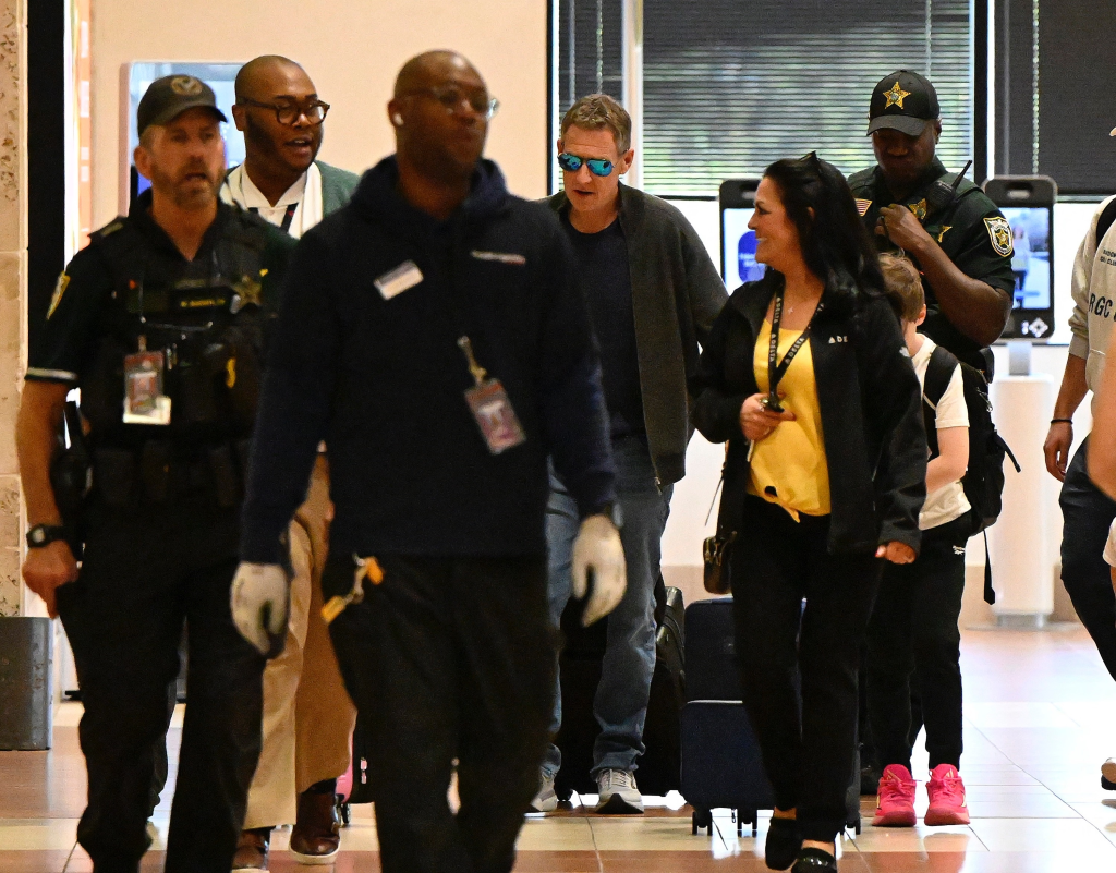 Michael Feldman with his children and security personnel at a Florida airport.
