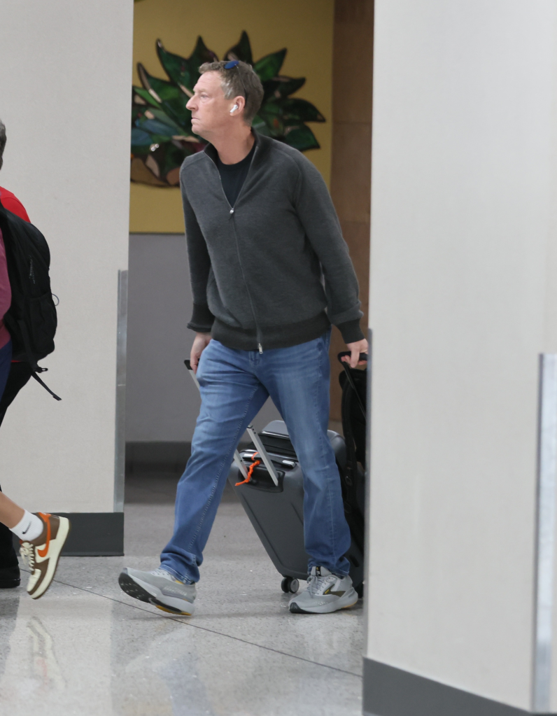 Michael Feldman pulling luggage at an airport.