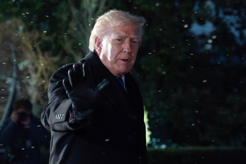 President Donald Trump gestures to reporters before departing the White House.