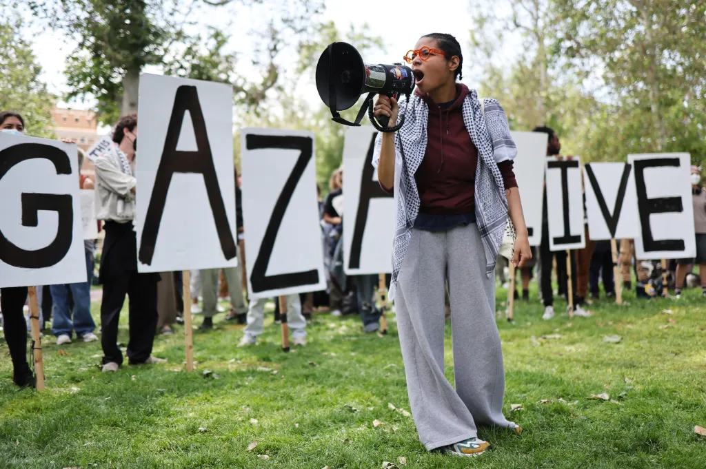 A pro-Palestine demonstrator shouts into a megaphone at an encampment with 