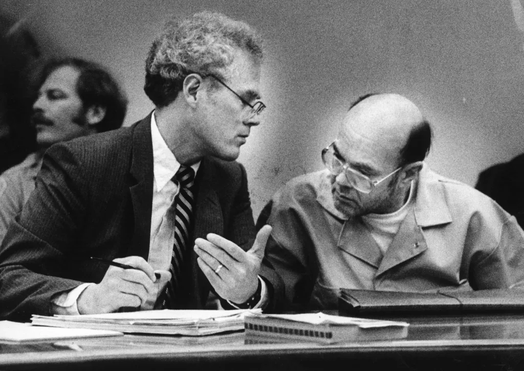 Public defender Frank Cox conferring with David Carpenter in court.