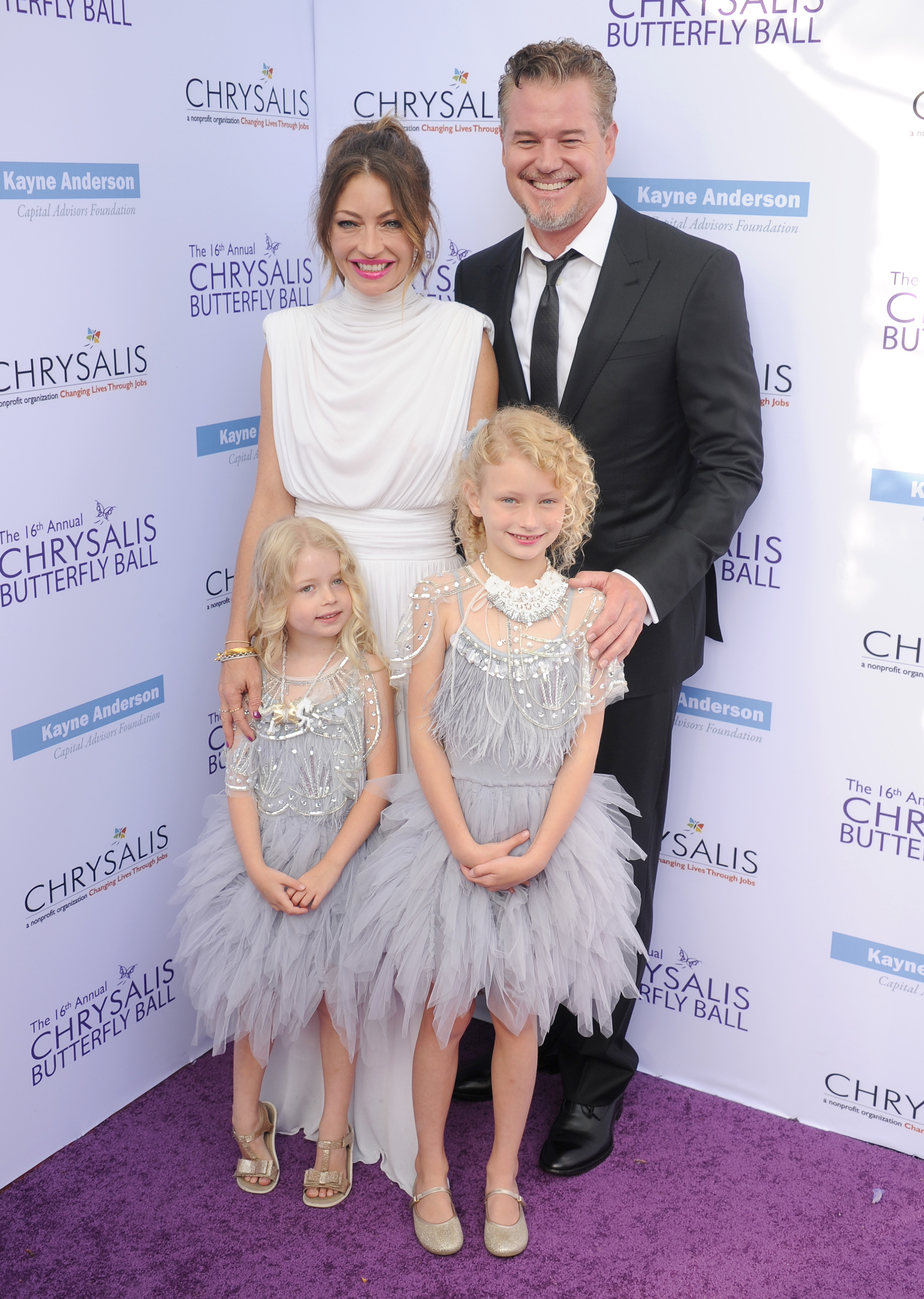 Rebecca Gayheart, Eric Dane, and their daughters Georgia and Billie on a purple carpet.