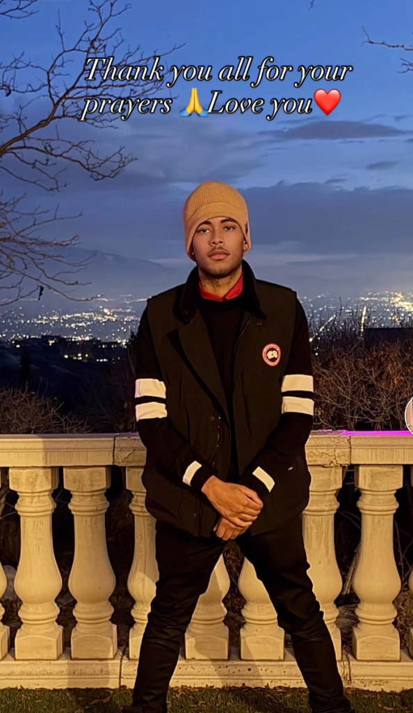 Robert Cosby Jr. standing outside at night with city lights in the background.