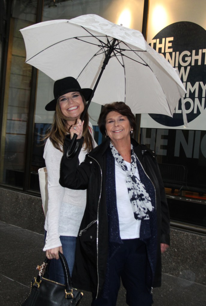 Savannah Guthrie and her mom pose under an umbrella outside the 
