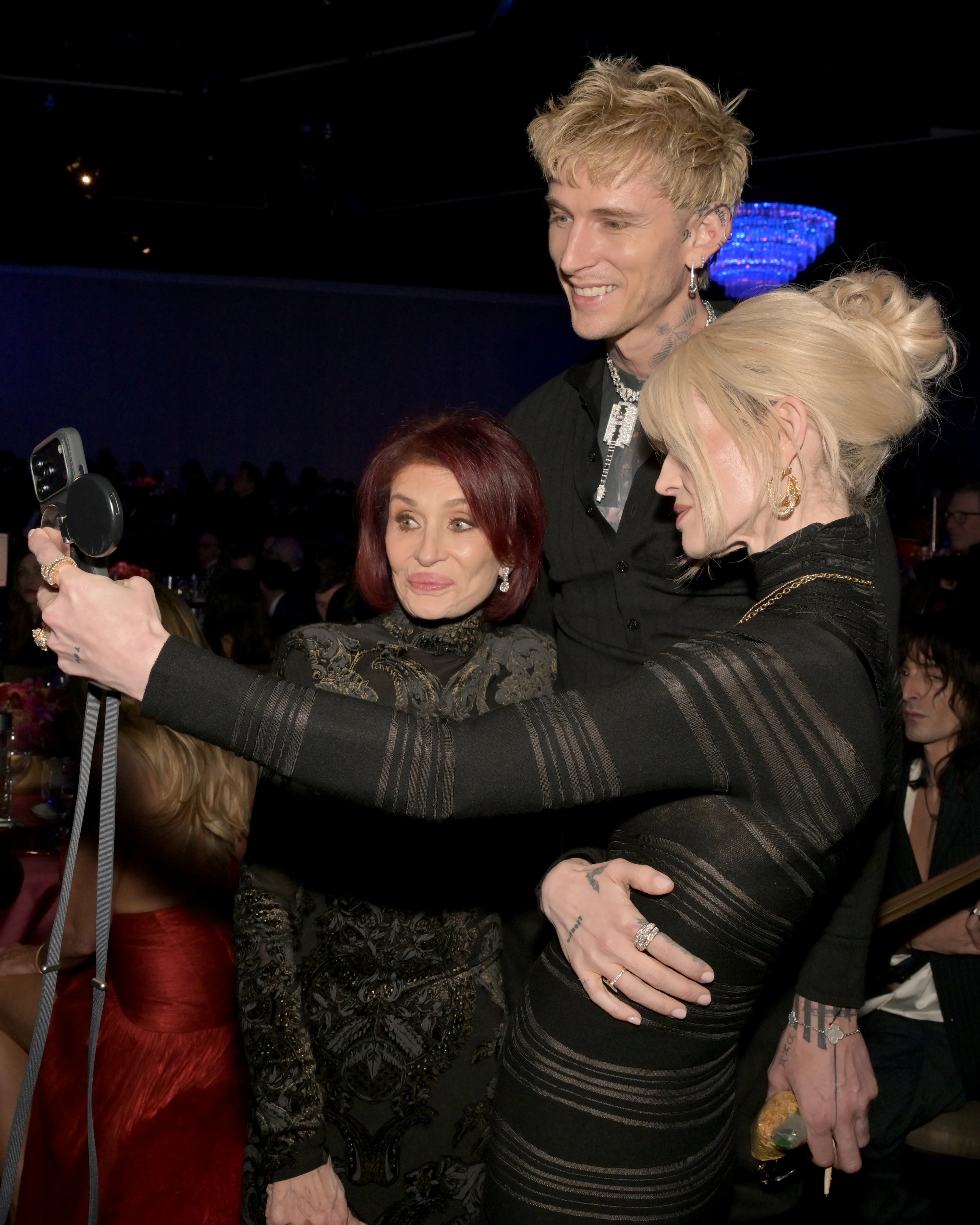Sharon Osbourne, Machine Gun Kelly, and Kelly Osbourne taking a selfie at the 68th GRAMMY Awards Pre-GRAMMY Gala.