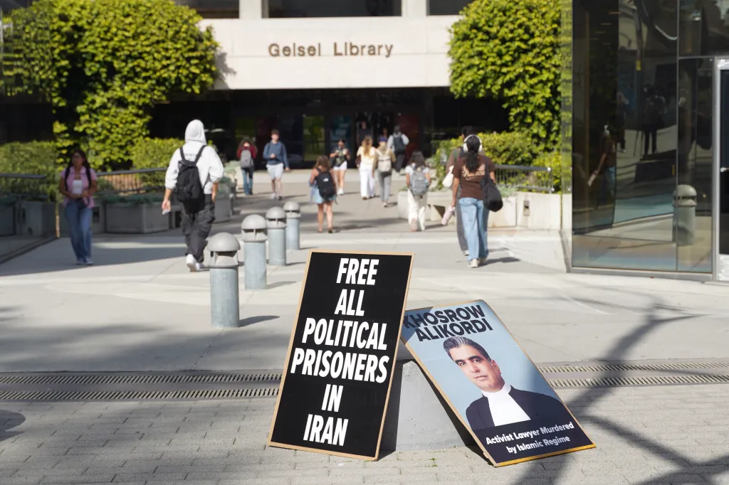 Protest signs for political prisoners in Iran and activist lawyer Khosrow Alikordi stand outside Gelsel Library at UC San Diego.