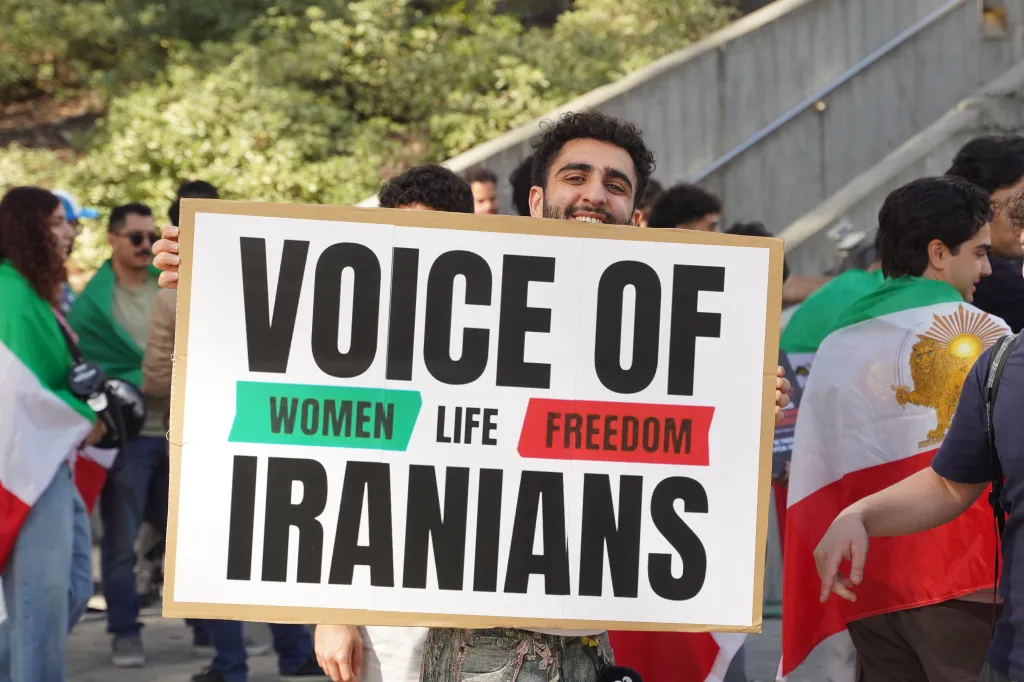 A young man holds a protest sign that reads 