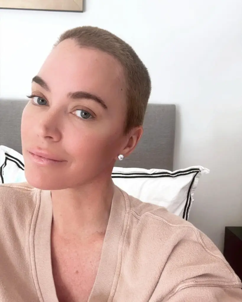 Teddi Mellencamp with a short buzz cut and diamond stud earrings, looking into the camera.