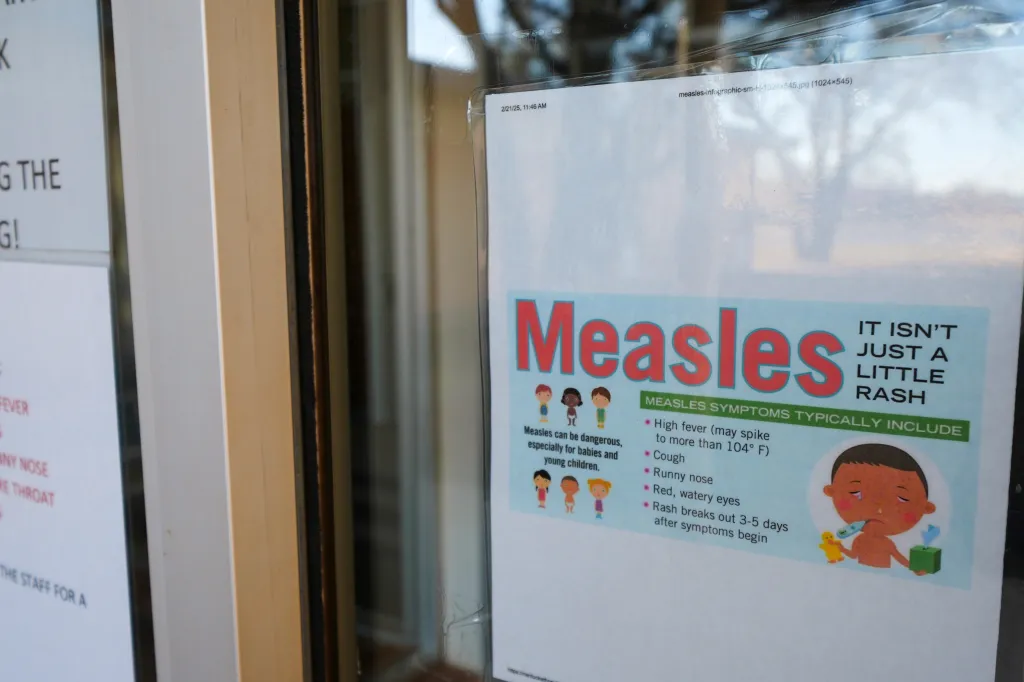 An illustration of a Measles warning sign seen outside a clinic.