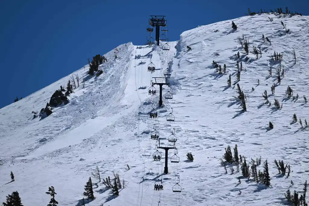 Skiers and snowboarders ride a lift at Mammoth Mountain Ski Area.