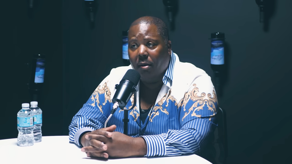 Bilaal Salaam speaking into a microphone.