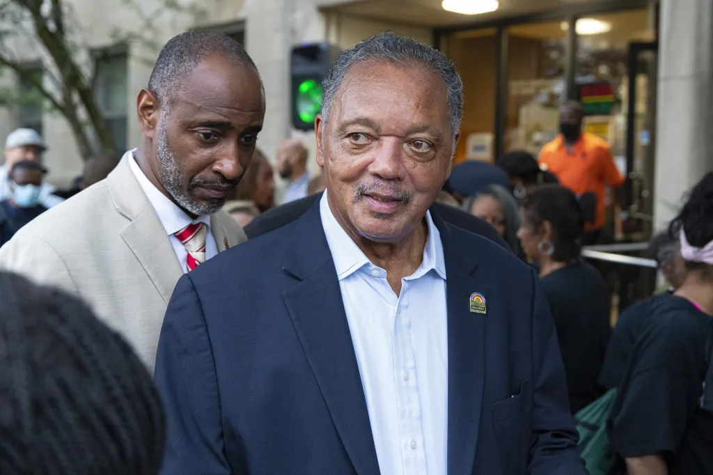 Rev. Jesse Jackson at a press conference with another man.