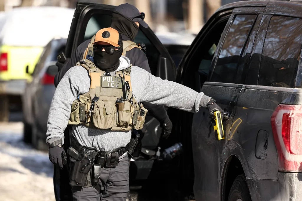 Federal agent, wearing a tactical vest labeled 