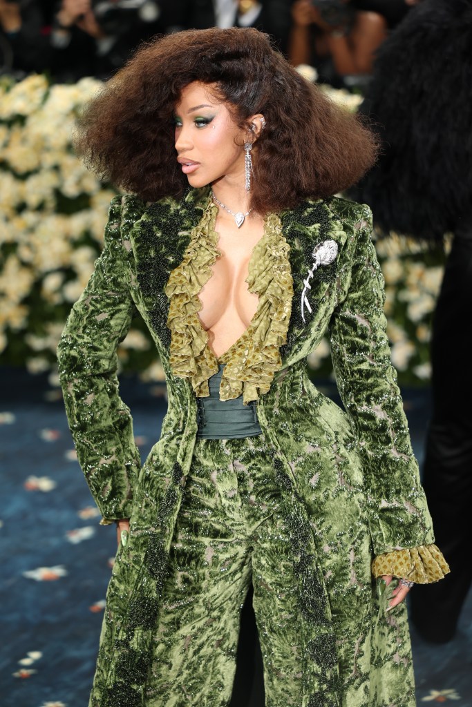 Cardi B in an elaborate green velvet suit with a ruffled neckline.