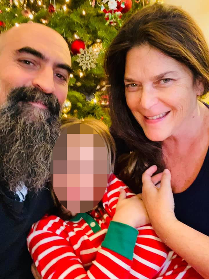 Tommaso Cioni and Annie Guthrie with a child in front of a Christmas tree.