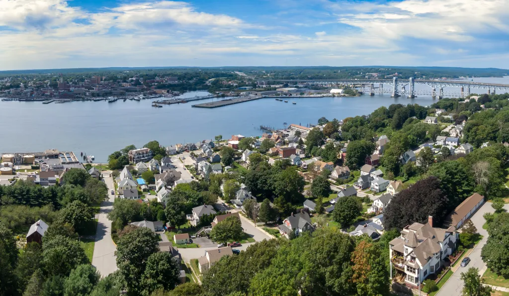 Aerial photo of Groton, Connecticut, looking over the Thames River to New London, with residential areas, boats, and a large bridge.