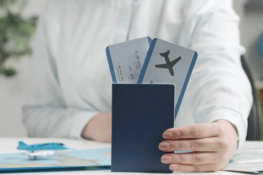 A travel agent holding a passport with airline tickets.