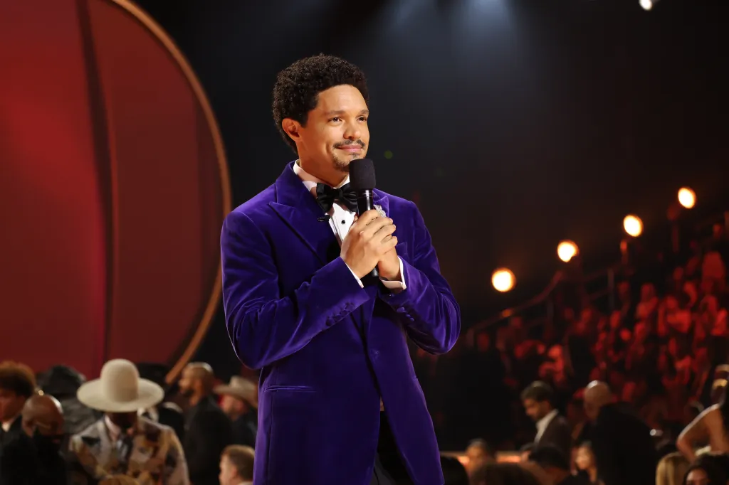 Trevor Noah speaking into a microphone onstage at the 68th GRAMMY Awards.