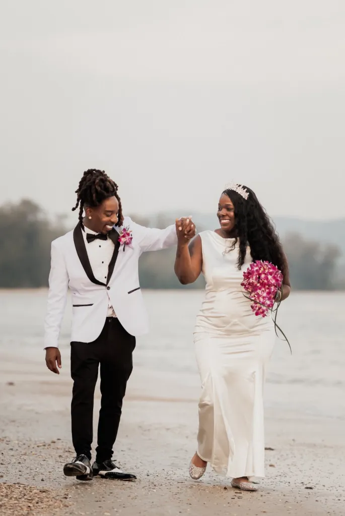 Tronderrica James and Travis James smiling while walking on a beach.