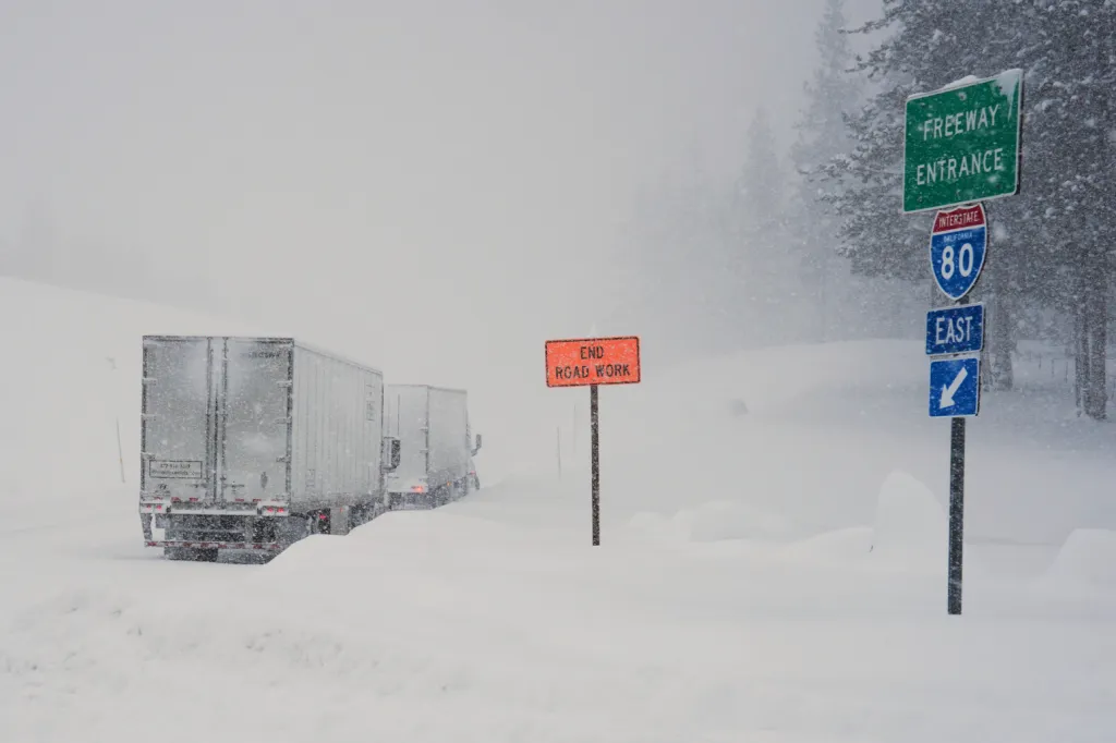 Trucks lined up on Interstate 80 during a snow storm.