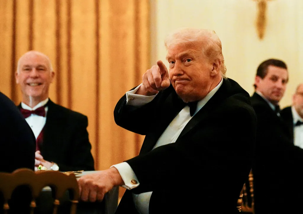 U.S. President Donald Trump, in a tuxedo, points his finger while attending a Governors Dinner.